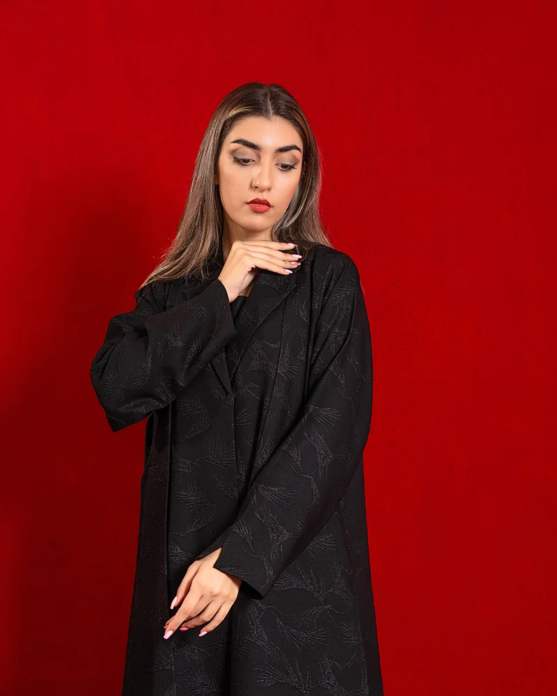 Black jacquard Blue Dan abaya on a red backdrop