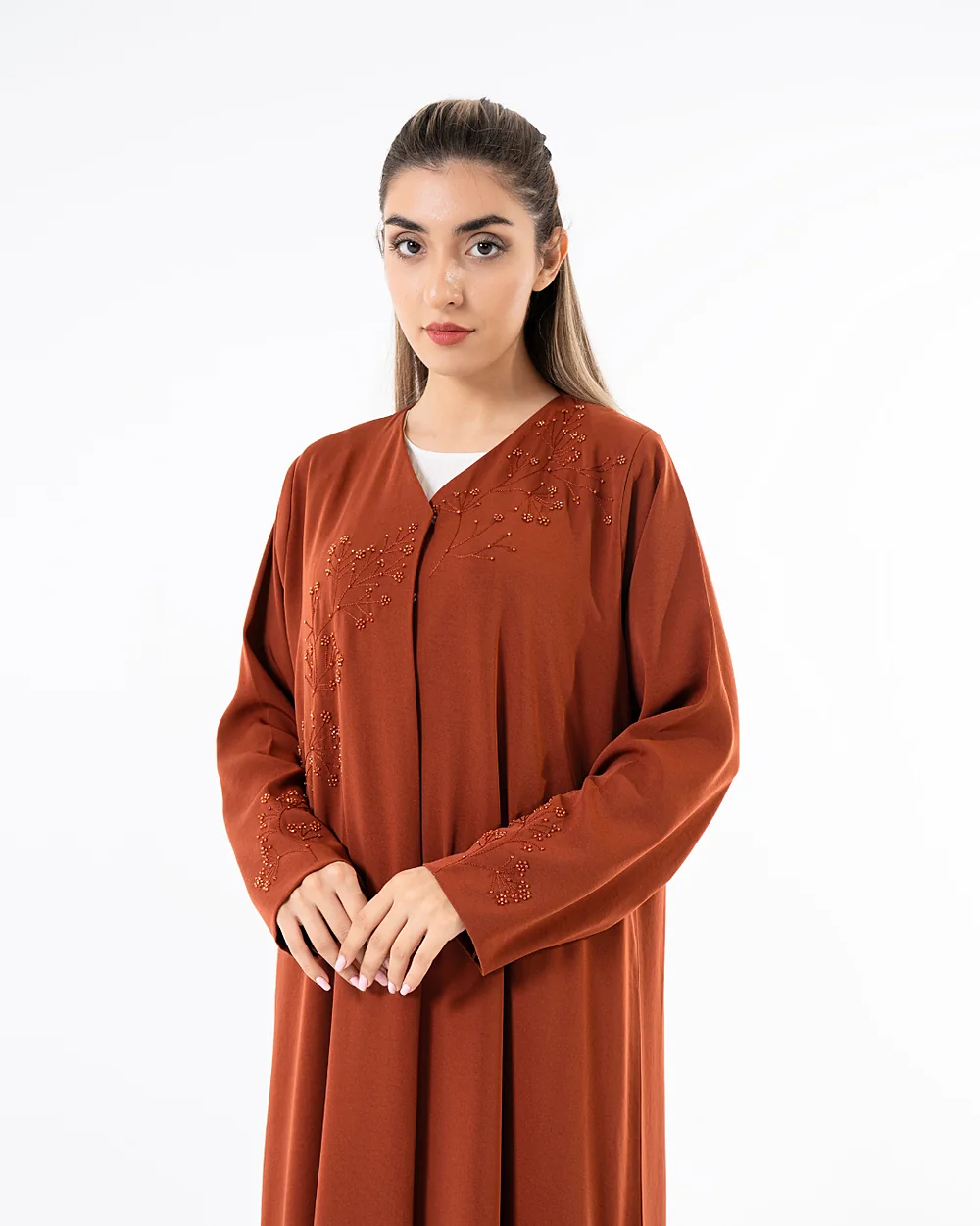 Model in a rust Blue Dan abaya with embroidered detailing